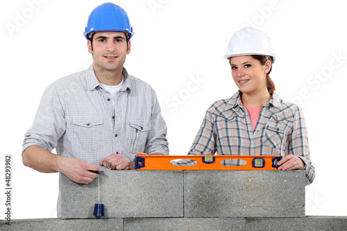 Photo: craftsman and craftswoman building a wall craftsman and craftswoman building a wall