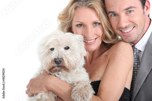 Photo: Couple cuddling dog. Couple cuddling dog.