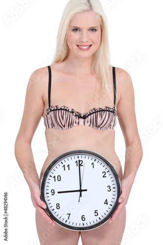 Photo: Woman in underwear holding wall clock Woman in underwear holding wall clock