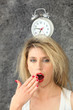 Blond woman with alarm clock on head