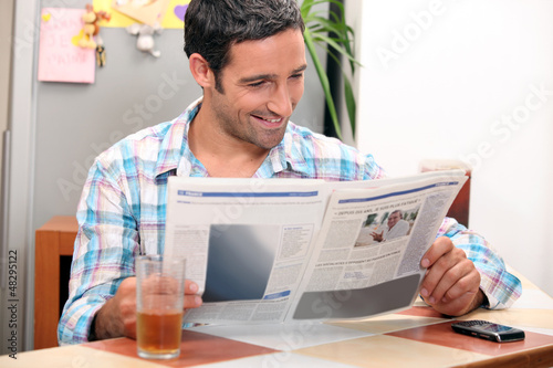 Photo: Man reading the newspaper in the morning. Man reading the newspaper in the morning.
