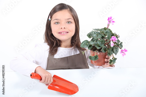 Photo: Little girl holding plant pot and trowel Little girl holding plant pot and trowel