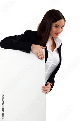 Photo: Alluring woman holding up a blank sign Alluring woman holding up a blank sign