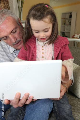 Photo: Grandfather with granddaughter and computer Grandfather with granddaughter and computer