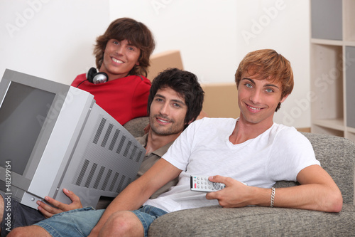 Photo: Three young men moving into to new house Three young men moving into to new house