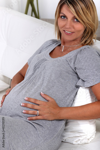 Photo: a pregnant woman touching her stomach a pregnant woman touching her stomach