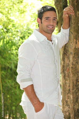 Photo: Man leaning against tree Man leaning against tree
