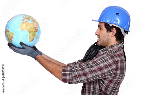 Photo: Laborer holding a globe Laborer holding a globe
