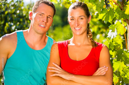 Photo: Woman and man standing in vineyard Woman and man standing in vineyard