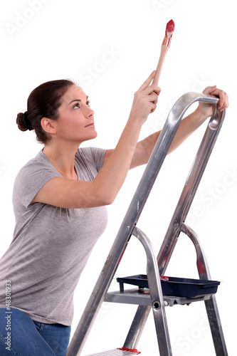 Photo: Woman with paint brush climbing step ladder Woman with paint brush climbing step ladder