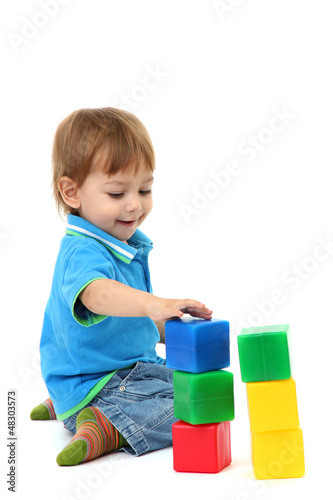 Photo: cute little boy with toy color cubes, isolated on white cute little boy with toy color cubes, isolated on white