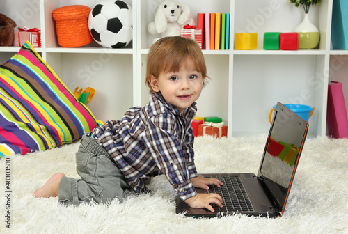 Photo: cute little boy and notebook in room cute little boy and notebook in room