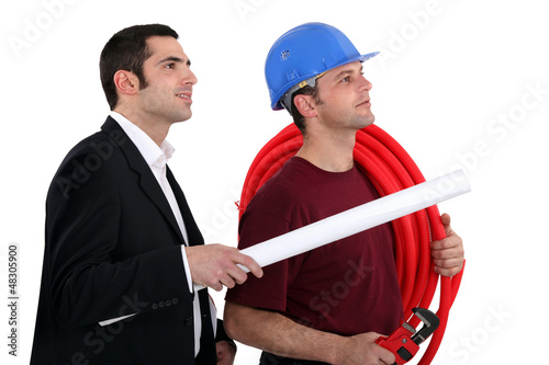 Photo: a plumber and a manager watching something a plumber and a manager watching something