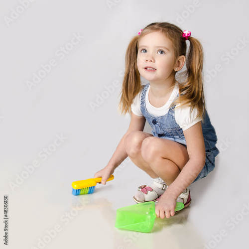 Photo: Cute little girl sweeps a floor Cute little girl sweeps a floor