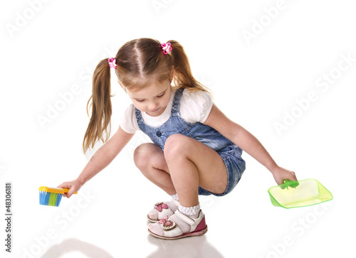 Photo: Cute little girl sweeps a floor isolated Cute little girl sweeps a floor isolated