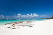 Wooden boat on tropical beach with white sand