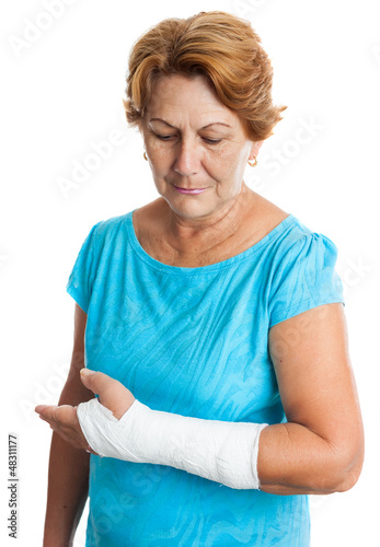 Photo: Woman with a broken arm on a plaster cast (isolated on white) Woman with a broken arm on a plaster cast (isolated on white)