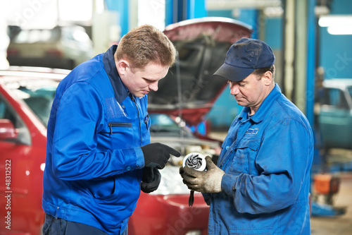 Photo: two car mechanic diagnosing auto engine problem two car mechanic diagnosing auto engine problem