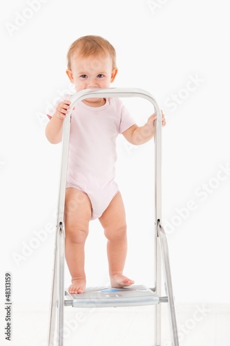 Photo: Impish little girl standing on top of ladder Impish little girl standing on top of ladder