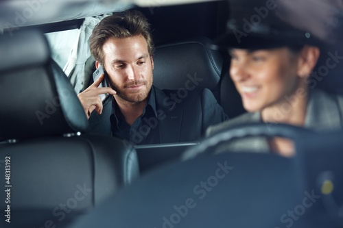 Photo: Businessman in limousine chauffeur driving Businessman in limousine chauffeur driving