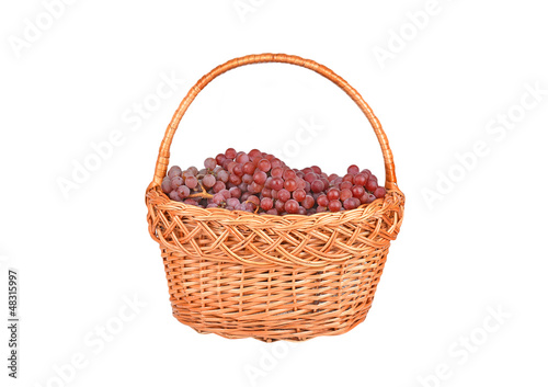 Photo: Red grape in a wattled basket, isolated on a white background Red grape in a wattled basket, isolated on a white background