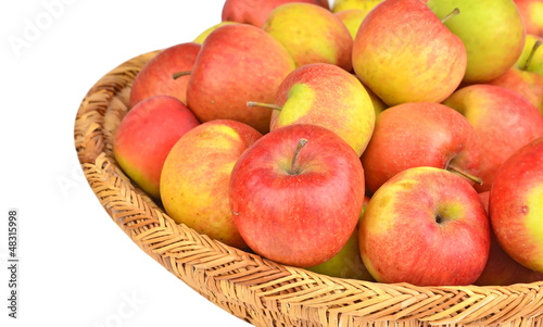 Photo: Red apple in a wattled basket, isolated on white background Red apple in a wattled basket, isolated on white background