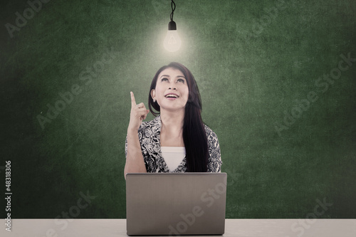 Photo: Businesswoman and lit bulb Businesswoman and lit bulb