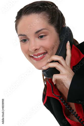 Photo: Brunette using land-line telephone Brunette using land-line telephone