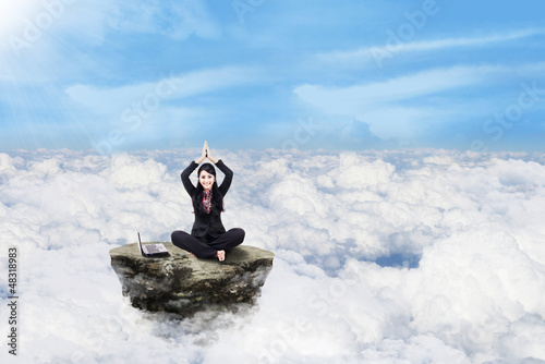 Photo: Businesswoman working above clouds Businesswoman working above clouds