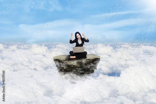 Photo: Happy businesswoman above clouds Happy businesswoman above clouds