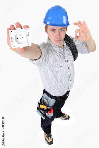 Photo: Electrician holding an electrical socket Electrician holding an electrical socket