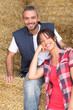 Farming couple sitting on hay