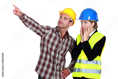 Photo: female architect looking appalled and male builder female architect looking appalled and male builder