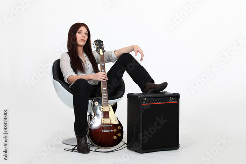 Photo: Woman with foot on an amplifier and holding guitar Woman with foot on an amplifier and holding guitar