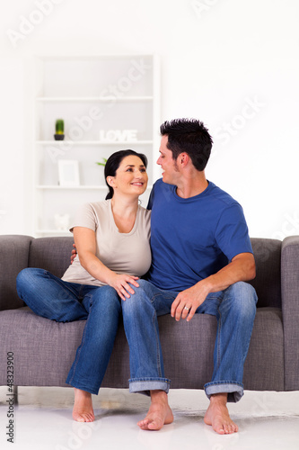 Photo: young couple sitting on sofa at home young couple sitting on sofa at home