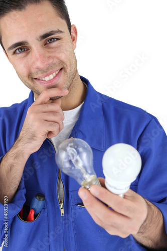 Photo: Young electrician smiling holding light bulbs Young electrician smiling holding light bulbs