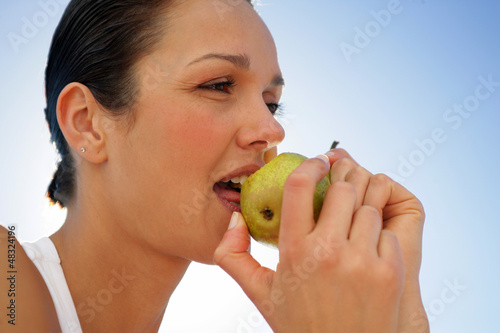 Photo: Woman biting into green apple Woman biting into green apple
