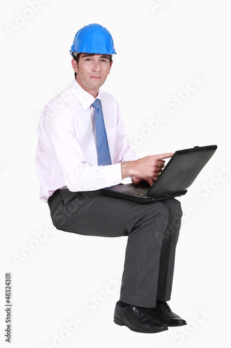 Photo: Engineer sitting in empty copyspace with a laptop Engineer sitting in empty copyspace with a laptop