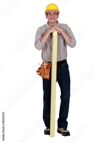 Photo: Carpenter stood with plank of wood Carpenter stood with plank of wood