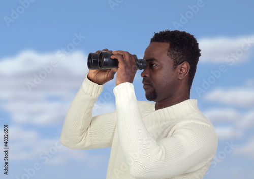 Photo: Attractive african man looking through binoculars Attractive african man looking through binoculars