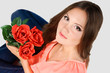 affectionate girl sitting on the floor with roses in her hands