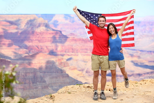 Photo: USA travel tourist couple holding american flag USA travel tourist couple holding american flag