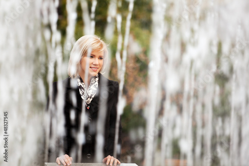 Photo: Happy young woman against a city fountain Happy young woman against a city fountain