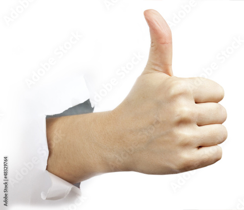 Photo: Hand with thumb up through a hole in paper Hand with thumb up through a hole in paper