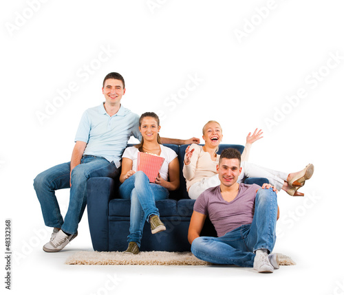 Photo: Young people sitting on a sofa smiling, on white background Young people sitting on a sofa smiling, on white background