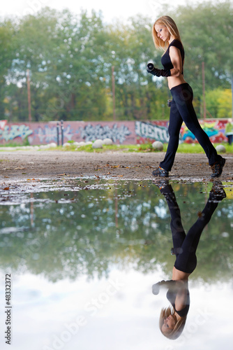 Photo: Woman lifting weights in urban setting Woman lifting weights in urban setting