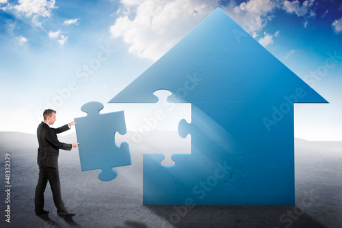 Photo: Businessman building a house jigsaw puzzle Businessman building a house jigsaw puzzle