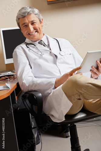 Photo: Happy Doctor Holding Digital Tablet Happy Doctor Holding Digital Tablet