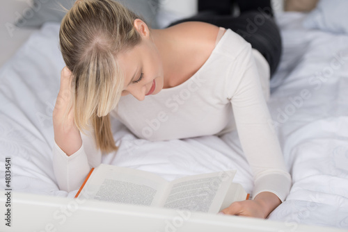 Photo: frau liest ein buch im bett frau liest ein buch im bett