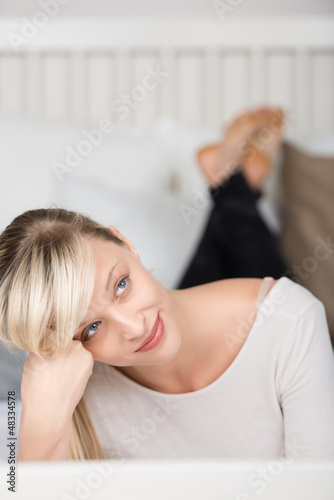 Photo: nachdenkliche schöne frau liegt auf dem bett nachdenkliche schöne frau liegt auf dem bett
